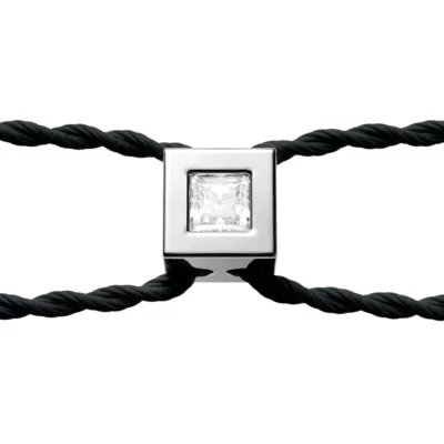 Négyzet alakú, ezüstözött karkötőfej, közepén gyémánttal. Fekete pántcsap és fehér háttér.